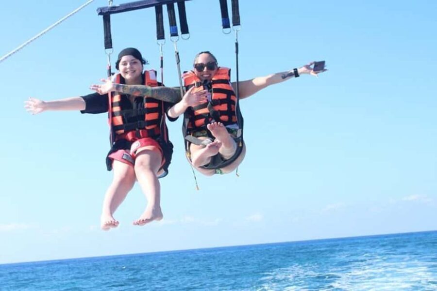 Parasailer soaring above clear waters with Cozumel beaches in the distance